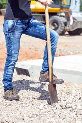 Mann tritt auf Spaten